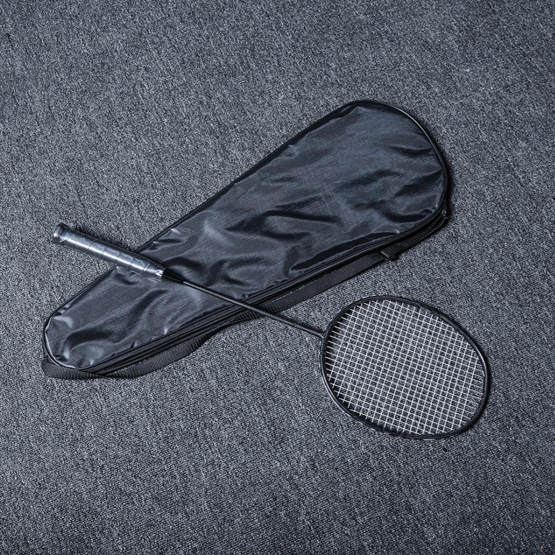 Close-up of a carbon fiber badminton racket with a black frame and string, placed next to a black racket cover on a gray textured surface.