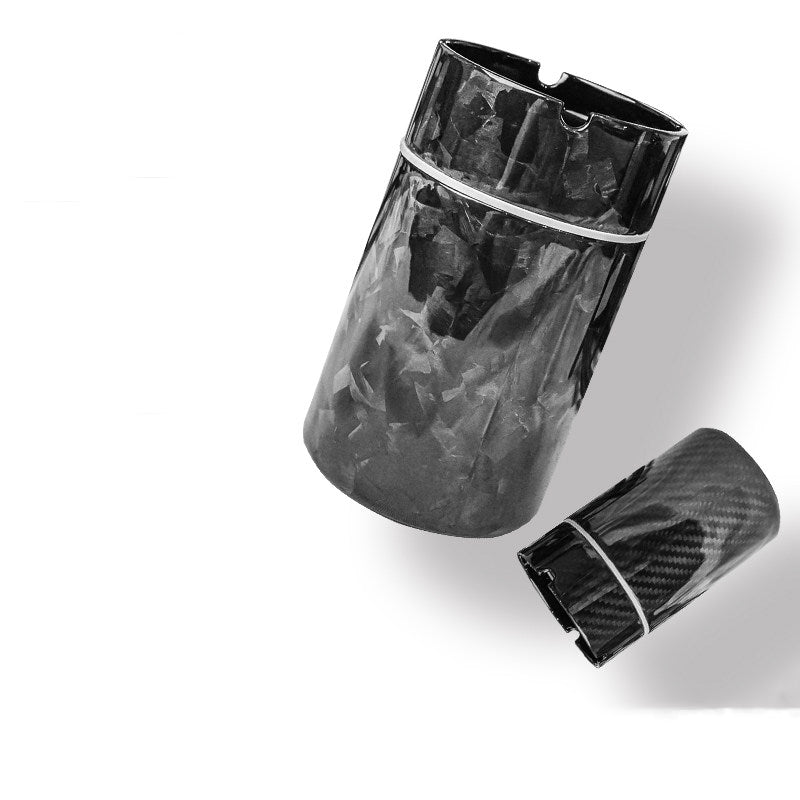 Close-up of two carbon fiber car ashtrays—one with a 3K carbon fiber pattern, the other with a forged carbon fiber pattern.