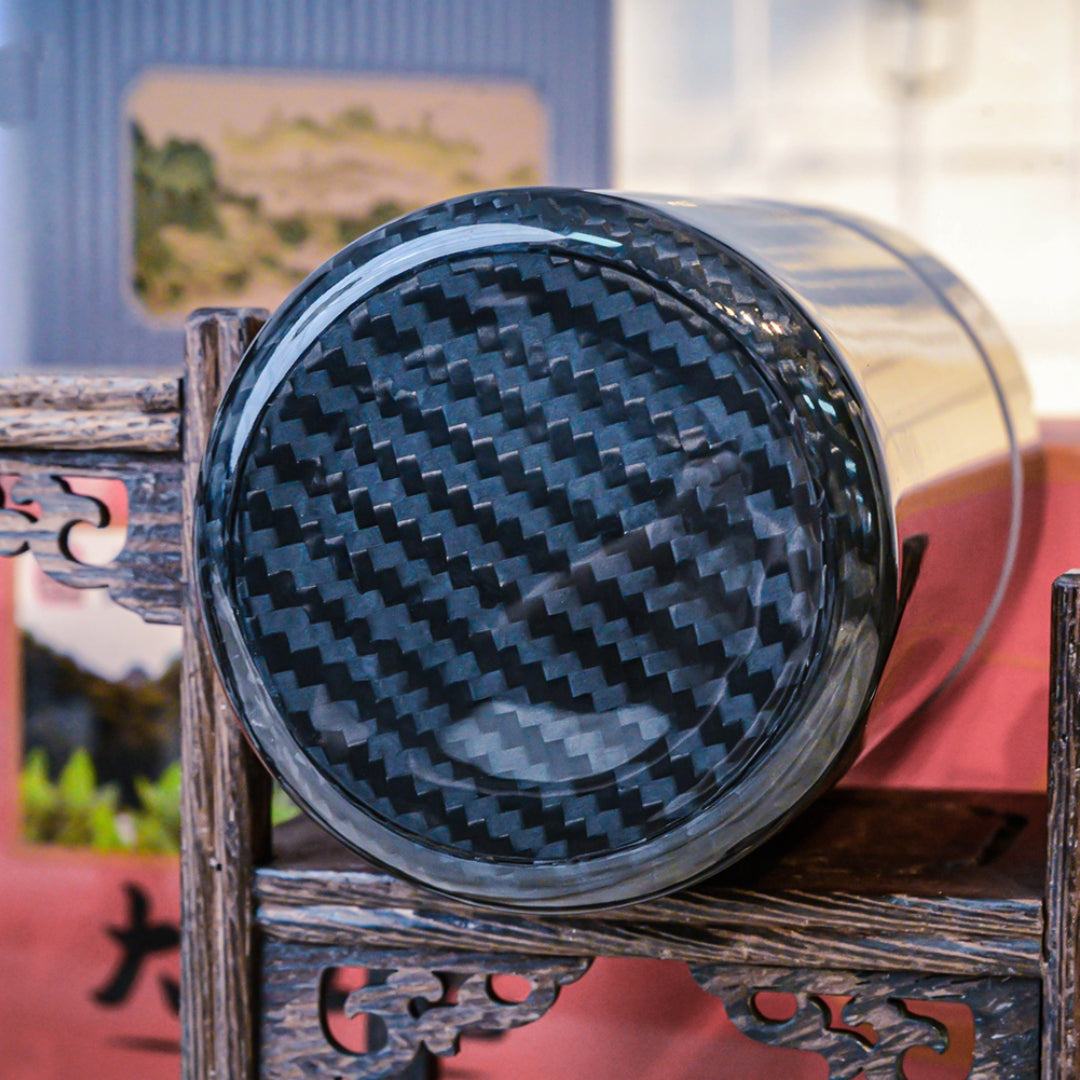 Close-up of the bottom of a 3K carbon fiber car ashtray, showcasing its distinct woven pattern, placed on traditional Chinese wooden craftsmanship.
