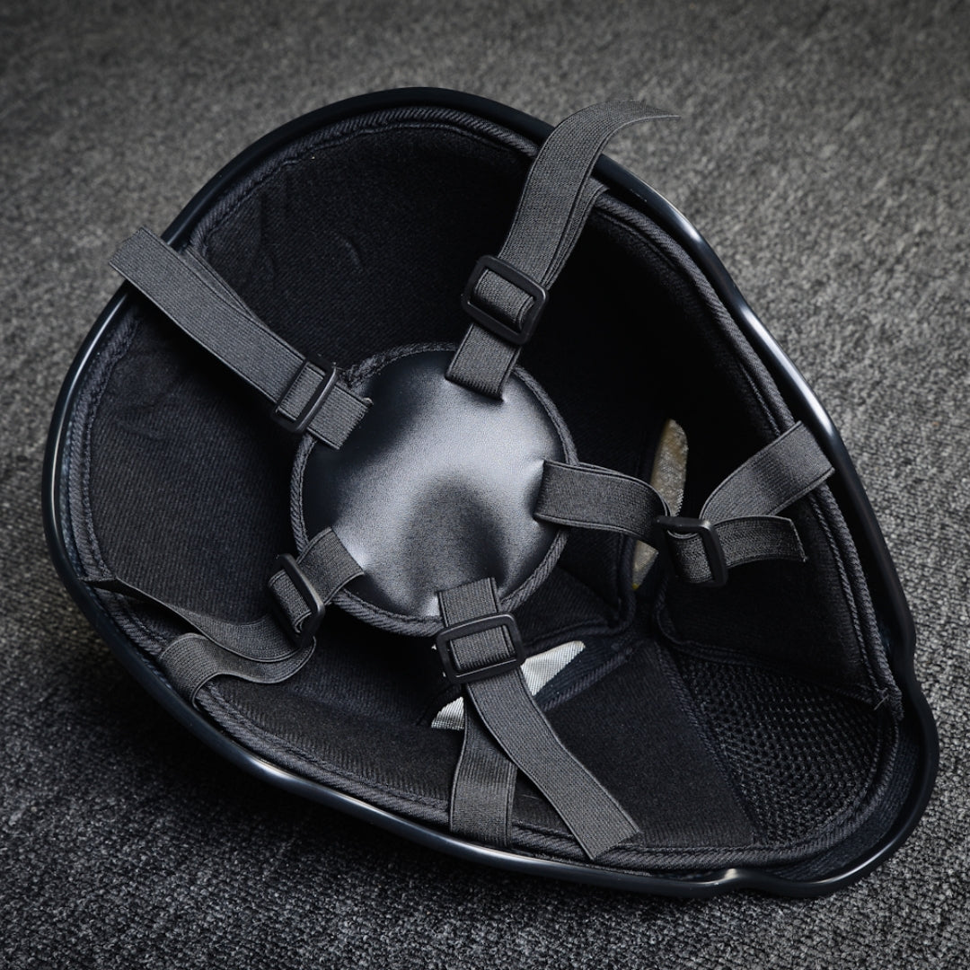 Close-up of the interior of a forged carbon fiber tactical mask, showcasing black padding, adjustable straps with buckle fasteners