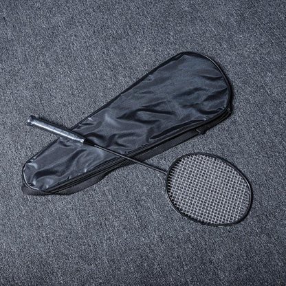 Close-up of a carbon fiber badminton racket with a black frame and string, placed next to a black racket cover on a gray textured surface.