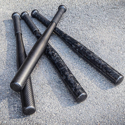 Four carbon fiber baseball bats with distinct weave patterns, placed on an asphalt surface.