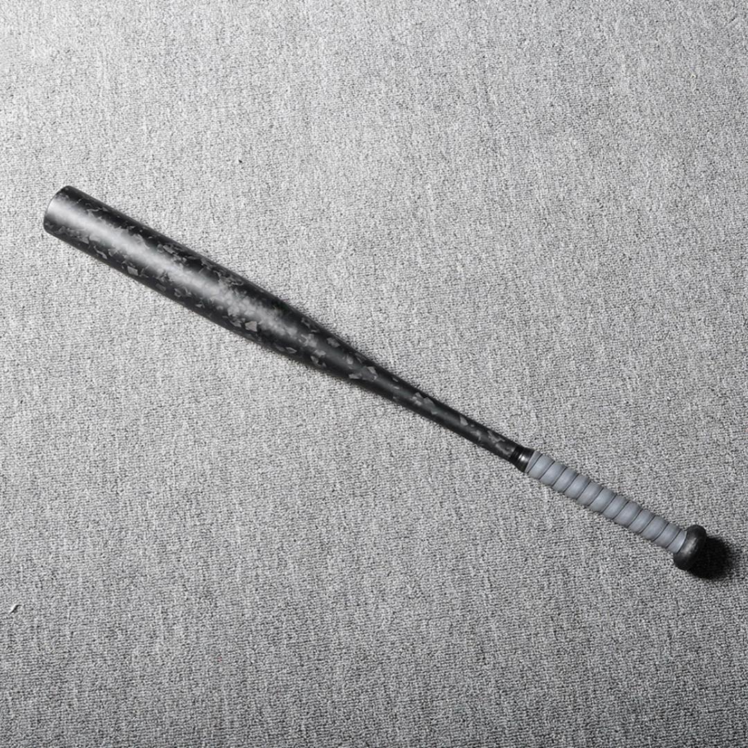 Forged carbon fiber baseball bat with a distinct chopped carbon fiber pattern and gray grip, laid on a gray textured surface.