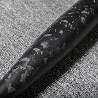 Close-up of a forged carbon fiber baseball bat showcasing the distinct chopped carbon fiber pattern, placed on a gray textured fabric surface.