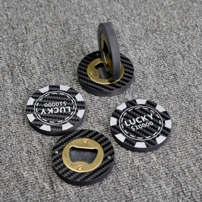 Close-up of multiple carbon fiber bottle openers, including poker chip-style ones with "LUCKY $10000" text and designs featuring brass bottle opener mechanisms, displayed on a gray textured surface.