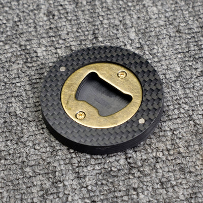 Close-up of a 3K carbon fiber bottle opener with a brass opener mechanism, showcasing its circular shape and distinct woven carbon fiber pattern