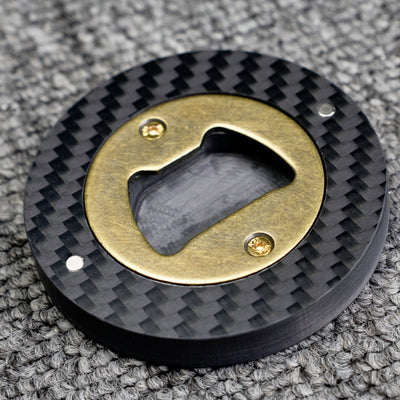 Close-up of a 3K carbon fiber bottle opener with a brass opener mechanism, showcasing its circular shape and distinct woven carbon fiber pattern