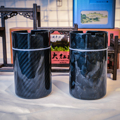 Close-up of two car ashtrays—one with a 3K carbon fiber pattern, the other with a forged carbon fiber pattern—displayed against a backdrop with traditional Chinese decorative elements.