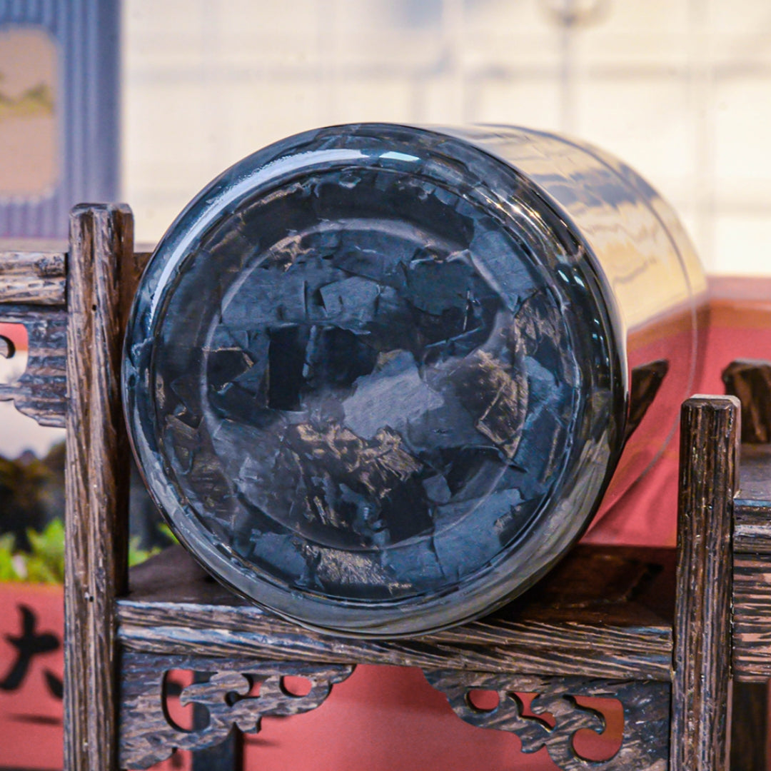 Close-up of the bottom of a forged carbon fiber car ashtray, showcasing its distinct fragmented pattern, placed on traditional Chinese wooden craftsmanship.