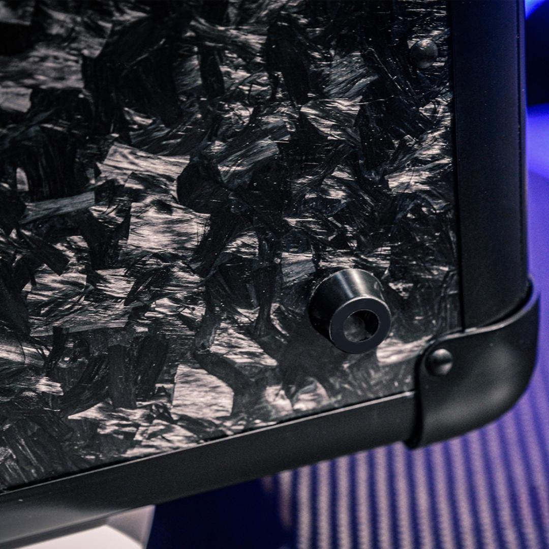 Close-up detail of the bottom part of a large forged carbon fiber car storage trunk, showcasing the chopped carbon fiber pattern and black metal components.