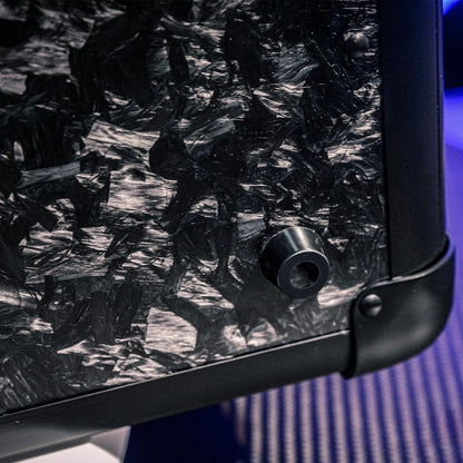 Close-up detail of the bottom part of a large forged carbon fiber car storage trunk, showcasing the chopped carbon fiber pattern and black metal components.