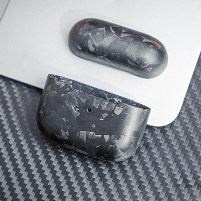 Close-up of forged carbon fiber AirPods cases showcasing the unique marbled texture