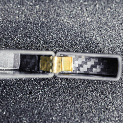 Close-up of the hinge area of a 3K carbon fiber Zippo lighter case, showcasing the detailed carbon fiber weave pattern inside
