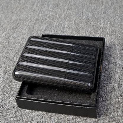 Close-up of a carbon fiber cigar case (capable of holding 5 cigars) featuring a textured pattern, placed in an open black box on a gray fabric surface.