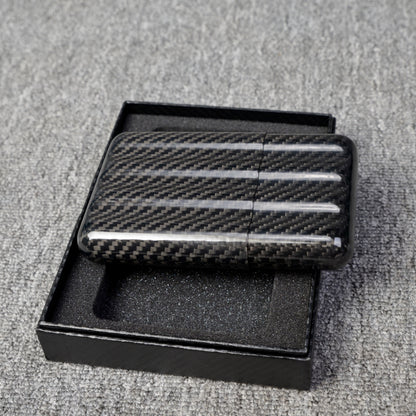 Close-up of a carbon fiber cigar case with a capacity for 4 cigars, featuring a distinct woven pattern, placed in an open black box with foam lining on a gray fabric surface.