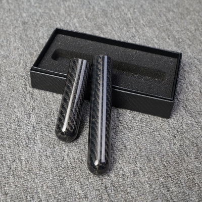 Close-up of two carbon fiber cigar tubes with single-cigar capacity, featuring a distinct woven pattern