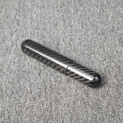 Close-up of a carbon fiber cigar tube with single-cigar capacity, featuring a distinct woven pattern, placed on a gray fabric surface.