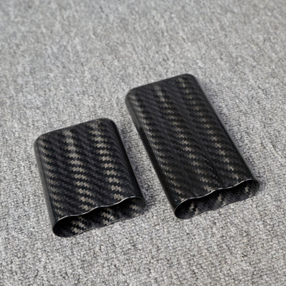 Close-up of carbon fiber cigar tubes with a capacity for 3 cigars, showcasing a distinct woven pattern, placed on a gray fabric surface.