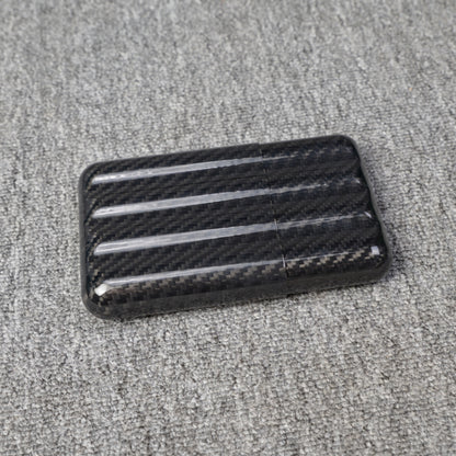 Close-up of a carbon fiber cigar case with a capacity for 4 cigars, featuring a distinct woven pattern, placed on a gray fabric surface.