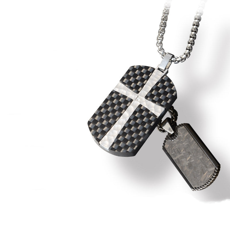 Close-up reveals a 3K carbon fiber and forged carbon fiber pendant adorned with a silver cross accented by micro-diamond details