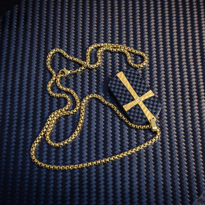 Close-up of a 3K carbon fiber pendant featuring a gold cross accent with a small diamond detail, paired with a gold-tone chain