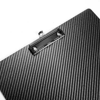 Close-up detail of a 3K carbon fiber clipboard with a distinctive woven textured pattern and a black metal clip, placed against a white background.