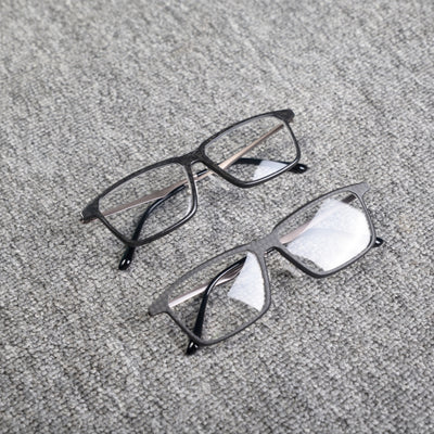 Close-up of two eyeglass frames made from forged carbon fiber and 3K carbon fiber, featuring sleek black designs with clear lenses