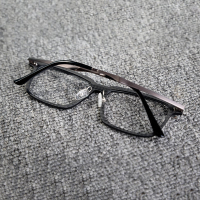 Close-up reverse side detail of a 3K carbon fiber eyeglass frame, showcasing its sleek black textured pattern and metallic temples