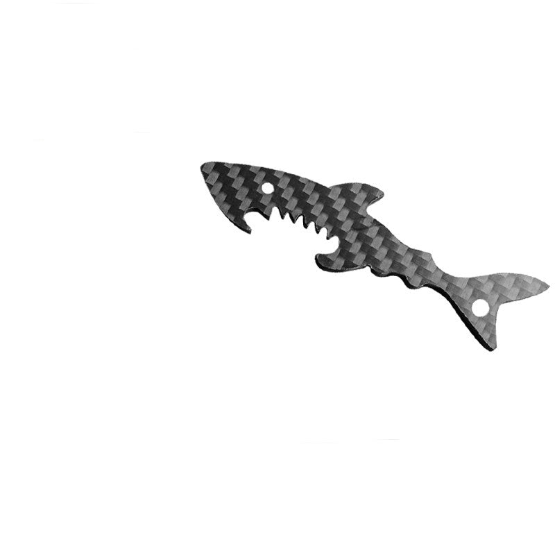 Close-up of a shark-shaped 3K carbon fiber keychain with a checkered pattern and serrated edge details.