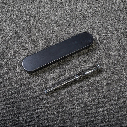 Close-up of a carbon fiber ballpoint pen with a distinct woven texture, accompanied by a sleek black metal case, displayed on a gray textured fabric surface.
