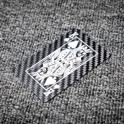 Close-up of a carbon fiber playing card featuring the King of Spades with white detailing, showcasing the distinct carbon fiber texture