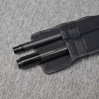 Two carbon fiber pool cue sections secured in a black fabric case, placed on a gray textured surface.