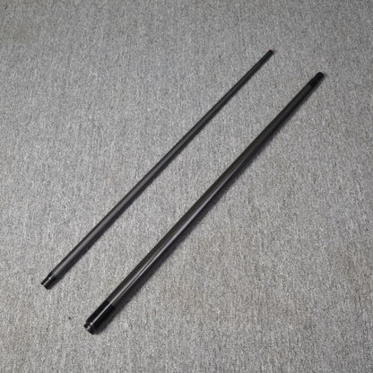 Two-piece carbon fiber pool cue laid out on a gray textured surface.