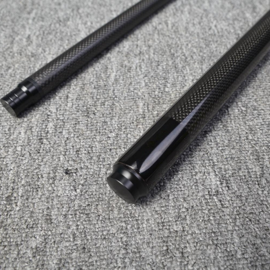Two-piece carbon fiber pool cue with a textured carbon fiber pattern, placed on a gray textured surface.
