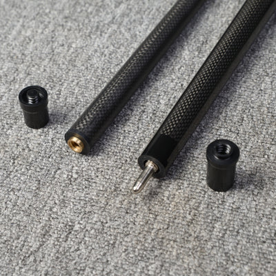 Close-up detail of a two-piece carbon fiber pool cue with a textured carbon fiber pattern, displaying the connecting components