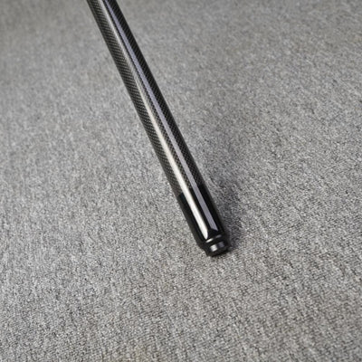 Close-up detail of the end of a carbon fiber pool cue, showcasing a textured carbon fiber pattern and a smooth black finish at the tip