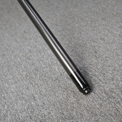 Close-up detail of the end of a carbon fiber pool cue, showcasing a smooth black finish at the tip and a textured carbon fiber pattern on the shaft