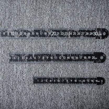 Three forged carbon fiber rulers with distinct lengths and clear measurement markings, placed on a textured surface.