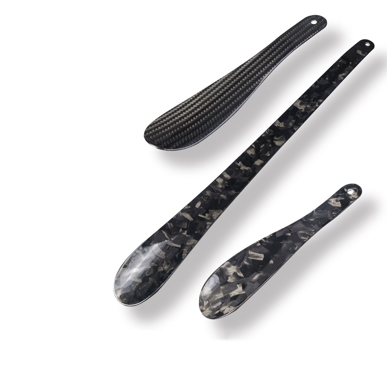Close-up details of three carbon fiber shoe horns—two feature a forged carbon fiber texture, while the third employs a 4K carbon fiber weave pattern.