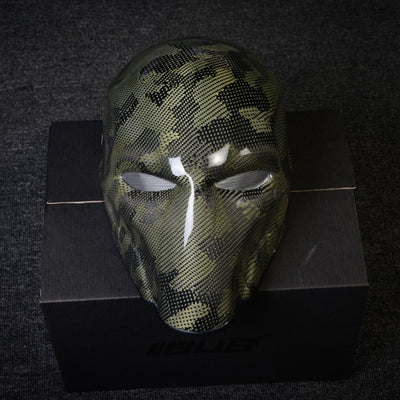 Close-up of a forged carbon fiber tactical mask with a camouflage pattern, mesh eye openings, and a glossy finish