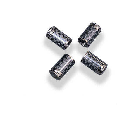 Close-up of four carbon fiber car tire valve stem caps with chrome detailing.