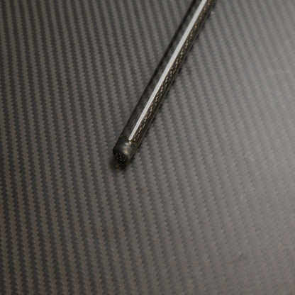 Close-up of the bottom part of a carbon fiber cane, showcasing the detailed carbon fiber weave pattern, placed on a carbon fiber textured surface.