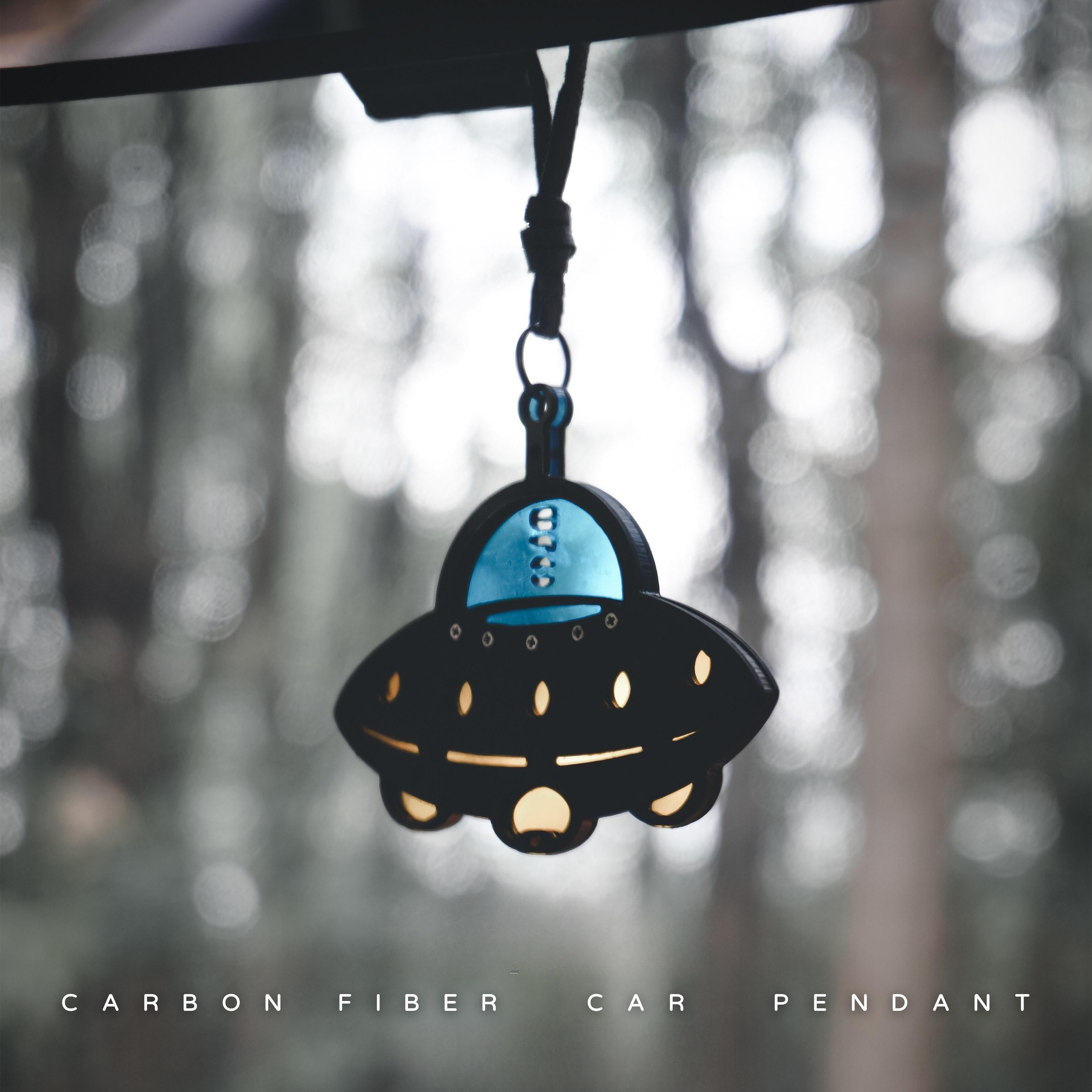 UFO-shaped carbon fiber car pendant: Features a black carbon fiber body, a glossy blue cockpit section (printed with "UFO"), it's set