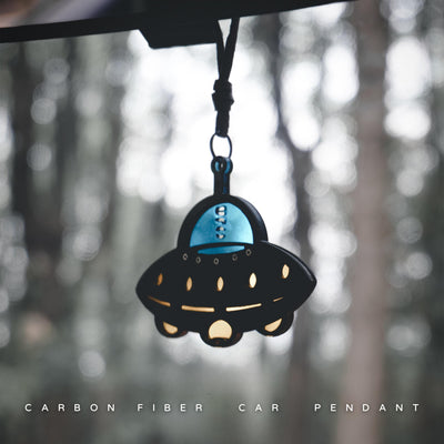 UFO-shaped carbon fiber car pendant: Features a black carbon fiber body, a glossy blue cockpit section (printed with "UFO"), it's set