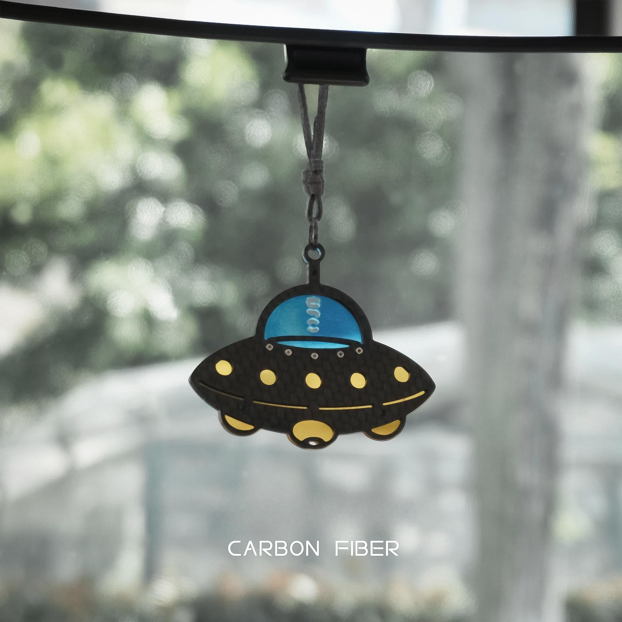 UFO-themed carbon fiber car pendant: Features a black carbon fiber-weave body, a glossy bright blue cockpit section (with "UFO" detailing)